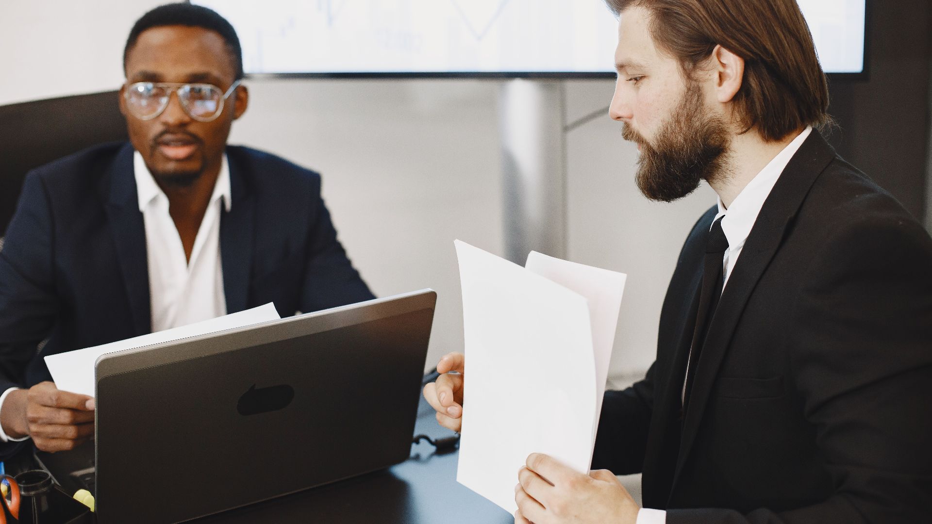 Two businessmen in a meeting discussing plans in a modern office.