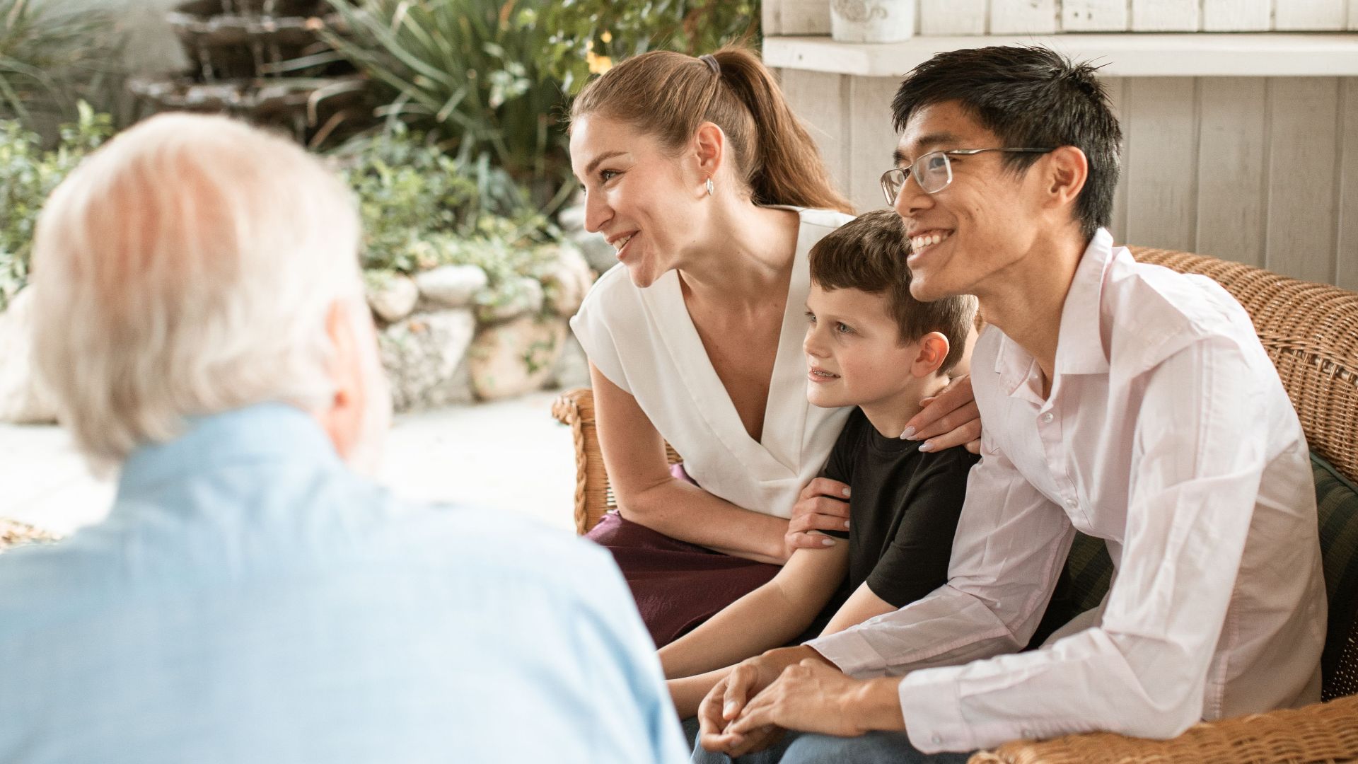 Diverse family bonding in a bright living room, sharing smiles and conversation.