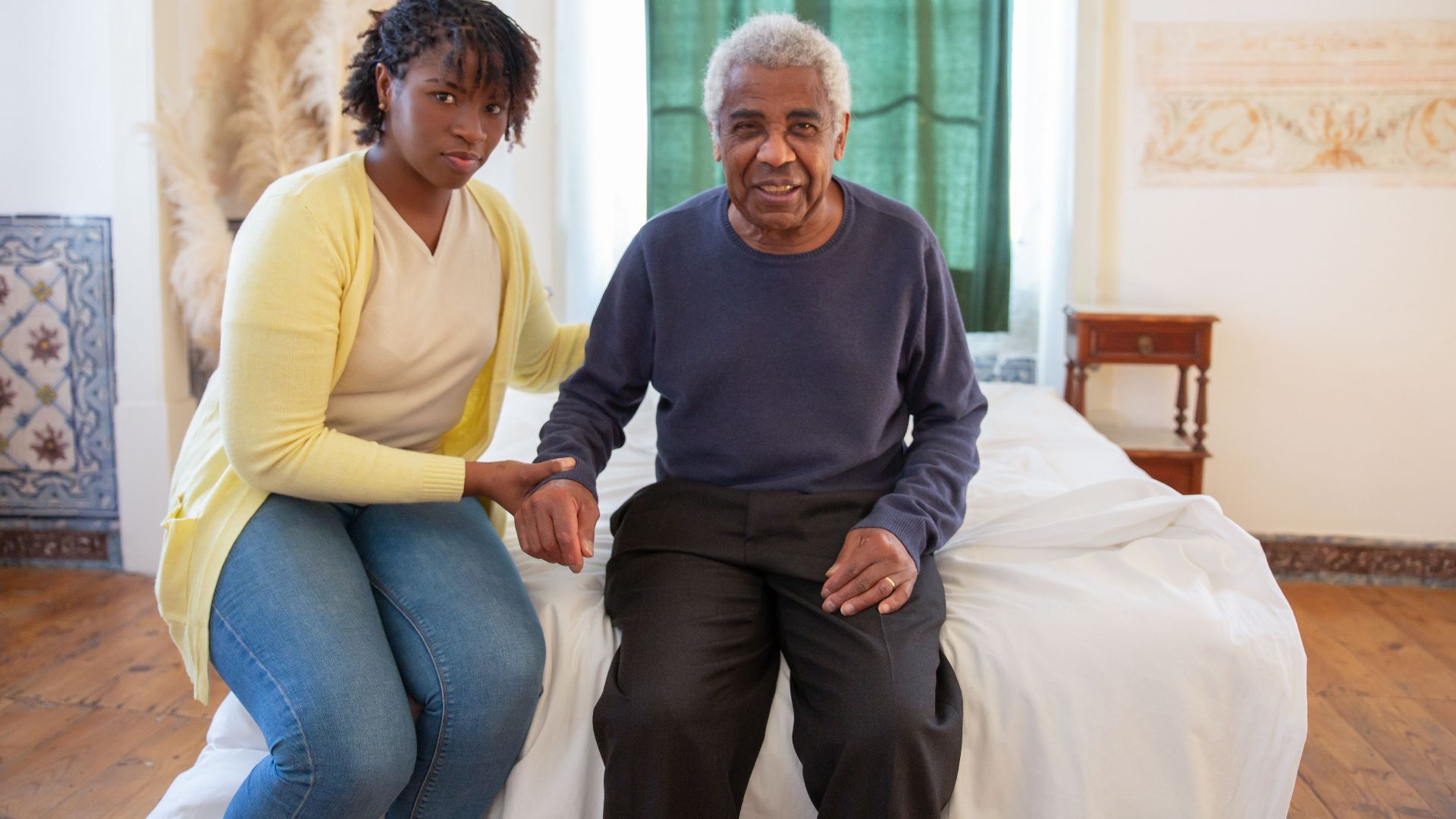 Daughter supporting elderly father in a bright, cozy room filled with love and warmth.