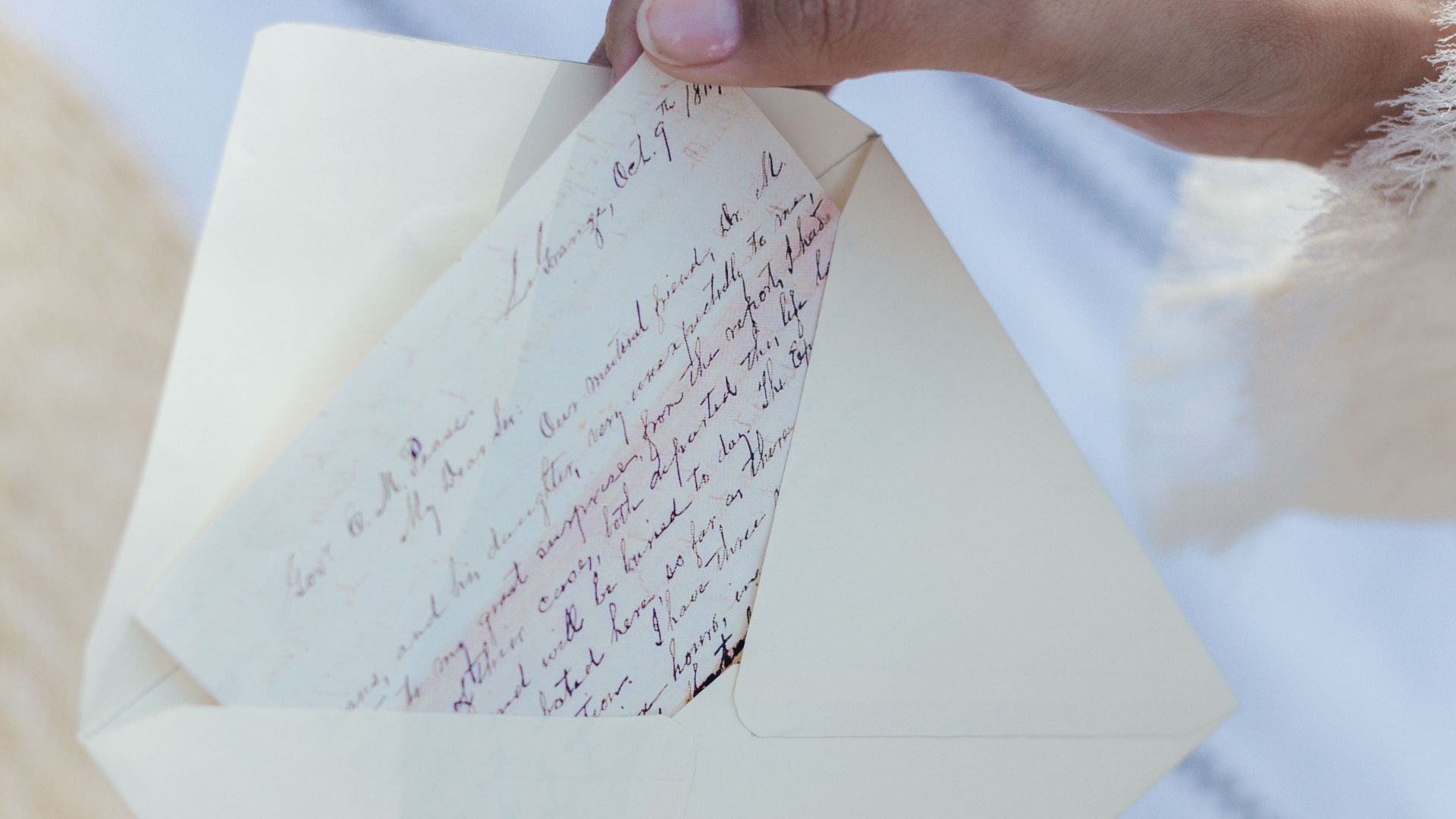 A woman's hands open an envelope containing a handwritten love letter, evoking nostalgia and romance.