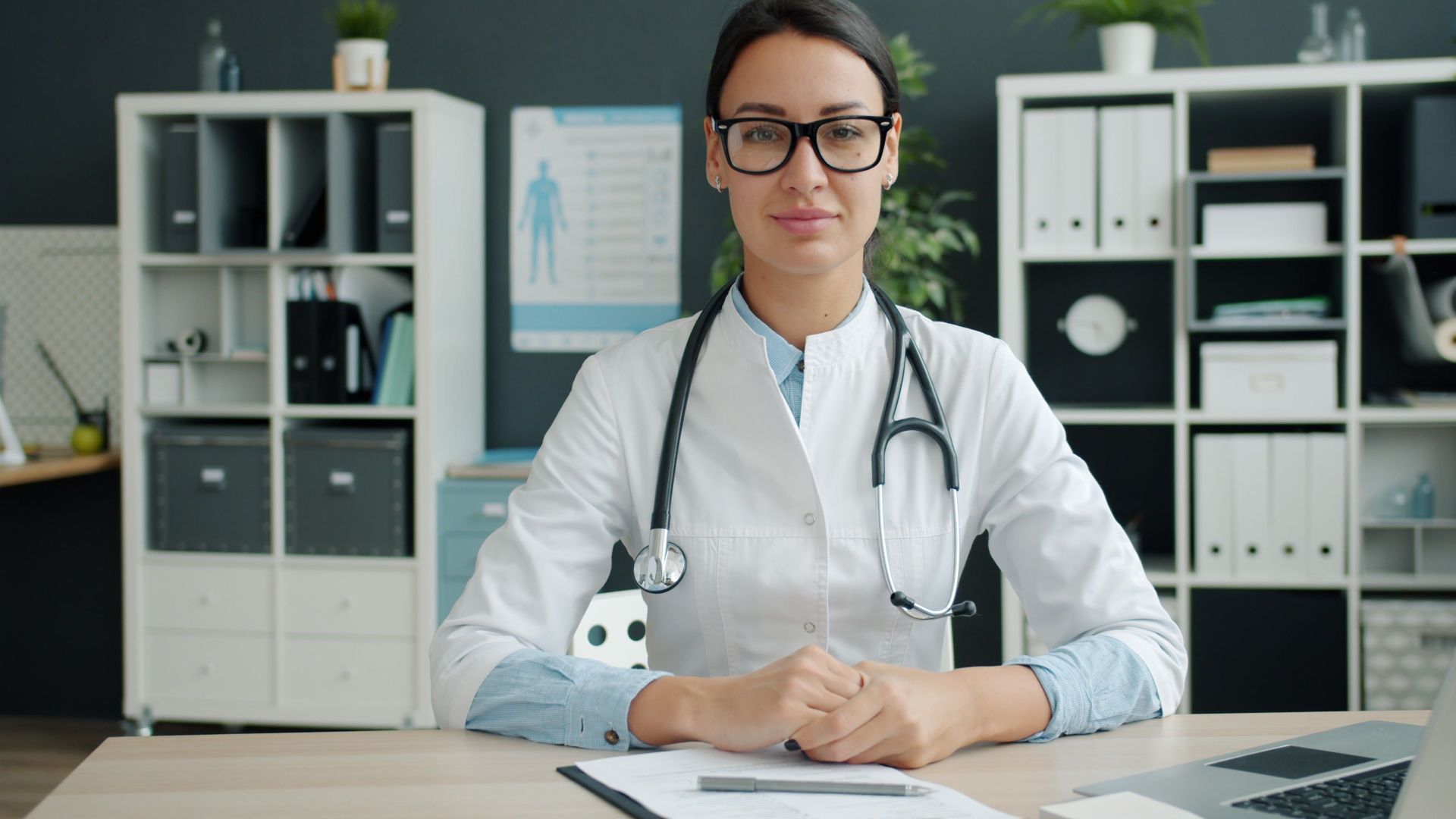 Professional female doctor sits confidently in a modern office.