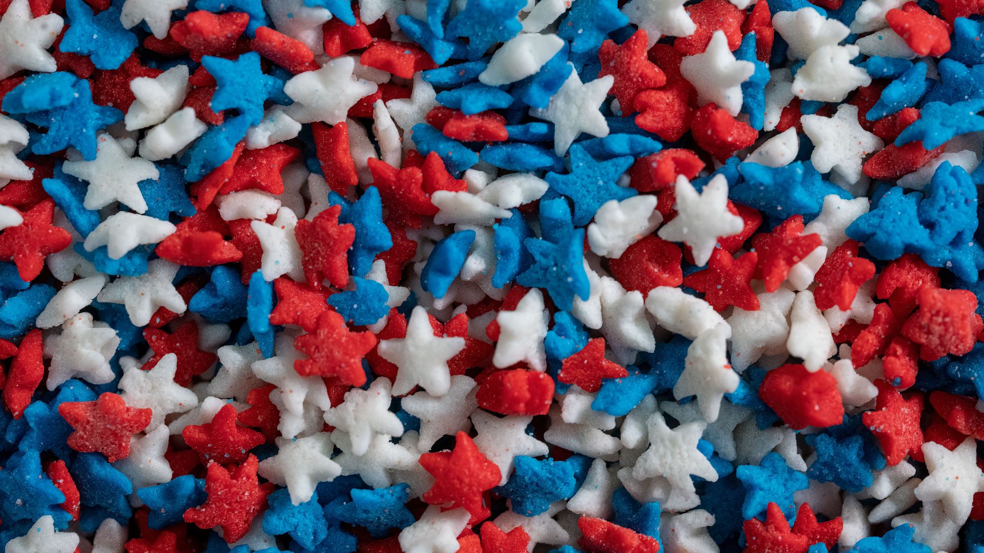 Bright red, white, and blue star sprinkles for celebrations and dessert decoration.