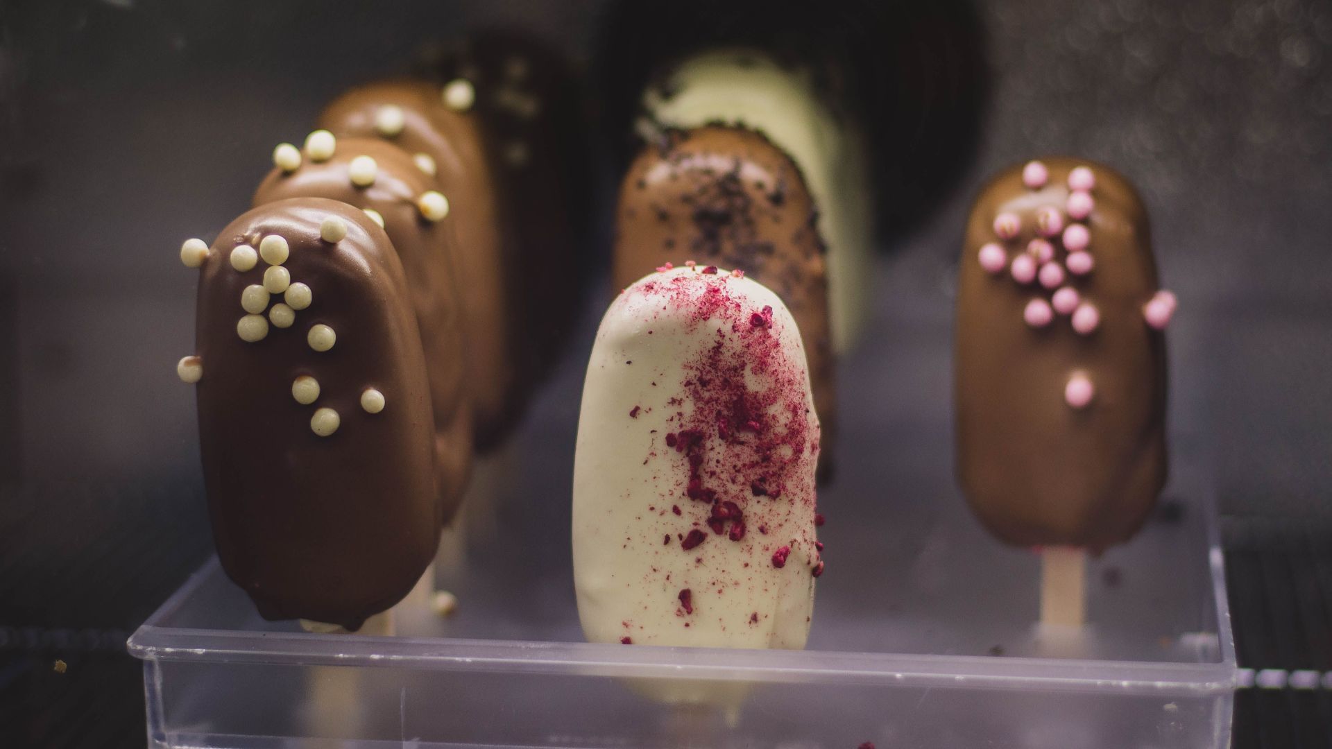 Close-up of delicious chocolate and vanilla ice cream bars with toppings, showcasing creamy indulgence.