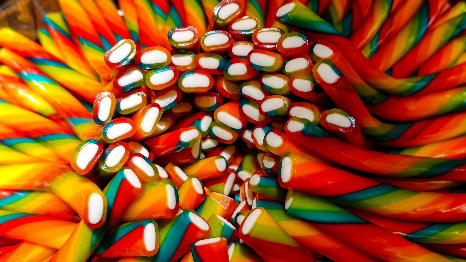 Close-up of colorful rainbow candy twists with vivid hues and intricate patterns.