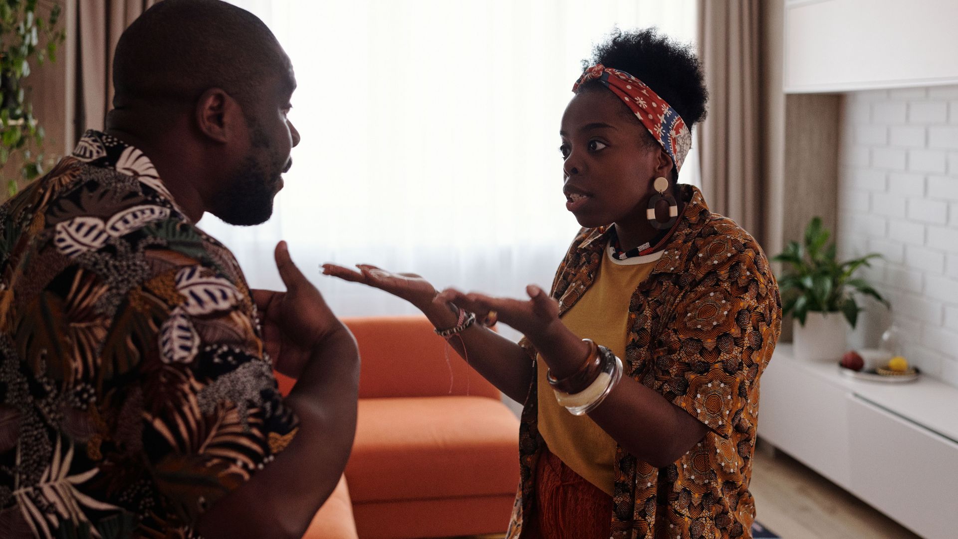 A couple arguing passionately in their living room, expressing emotions and gestures.
