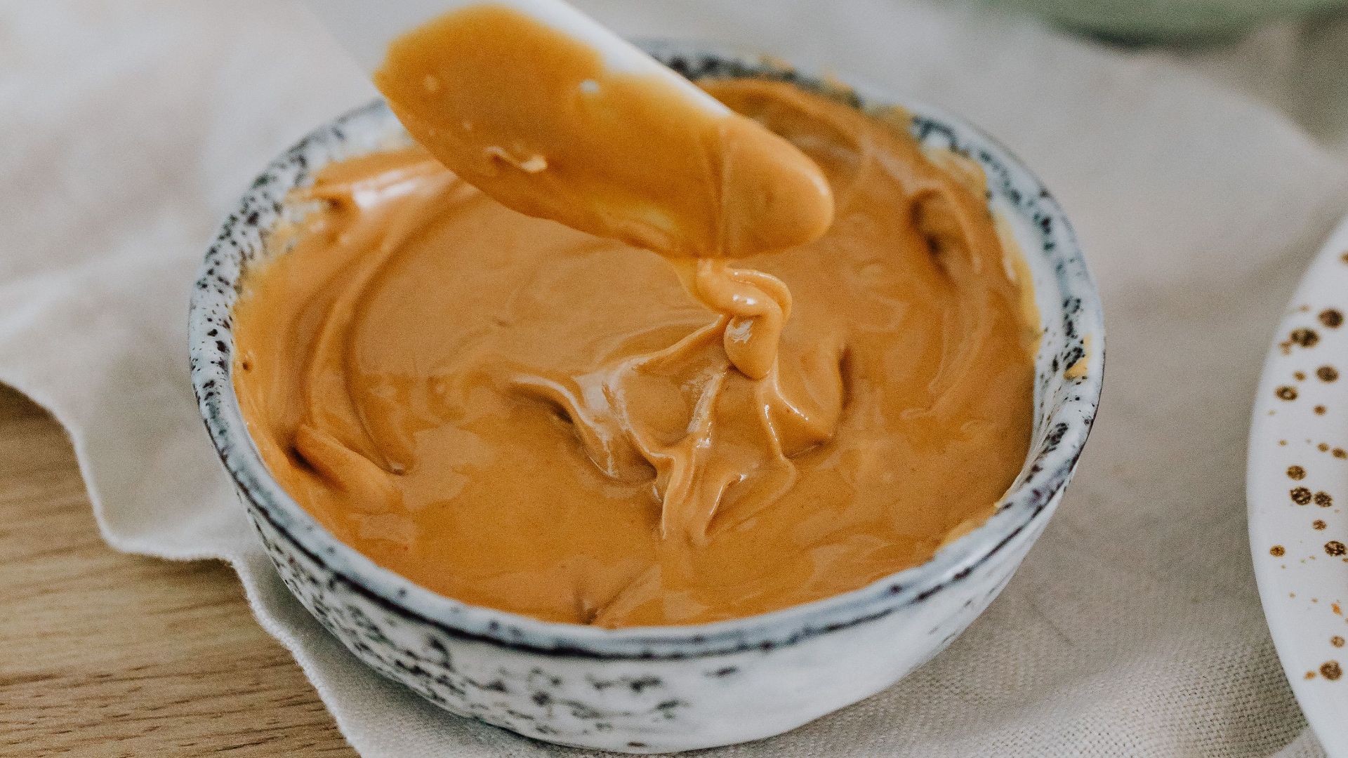 A cozy breakfast setup featuring creamy peanut butter, ready to spread on toast.