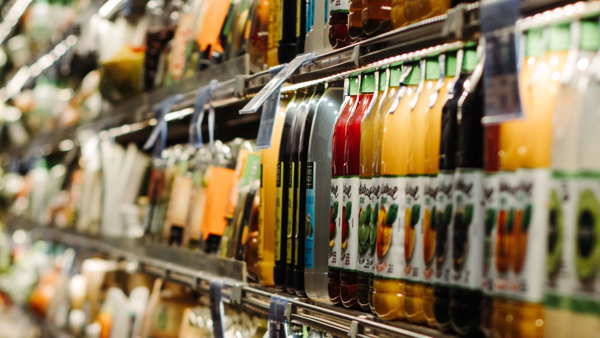 Vibrant array of bottled beverages on display in a Brazilian supermarket aisle.