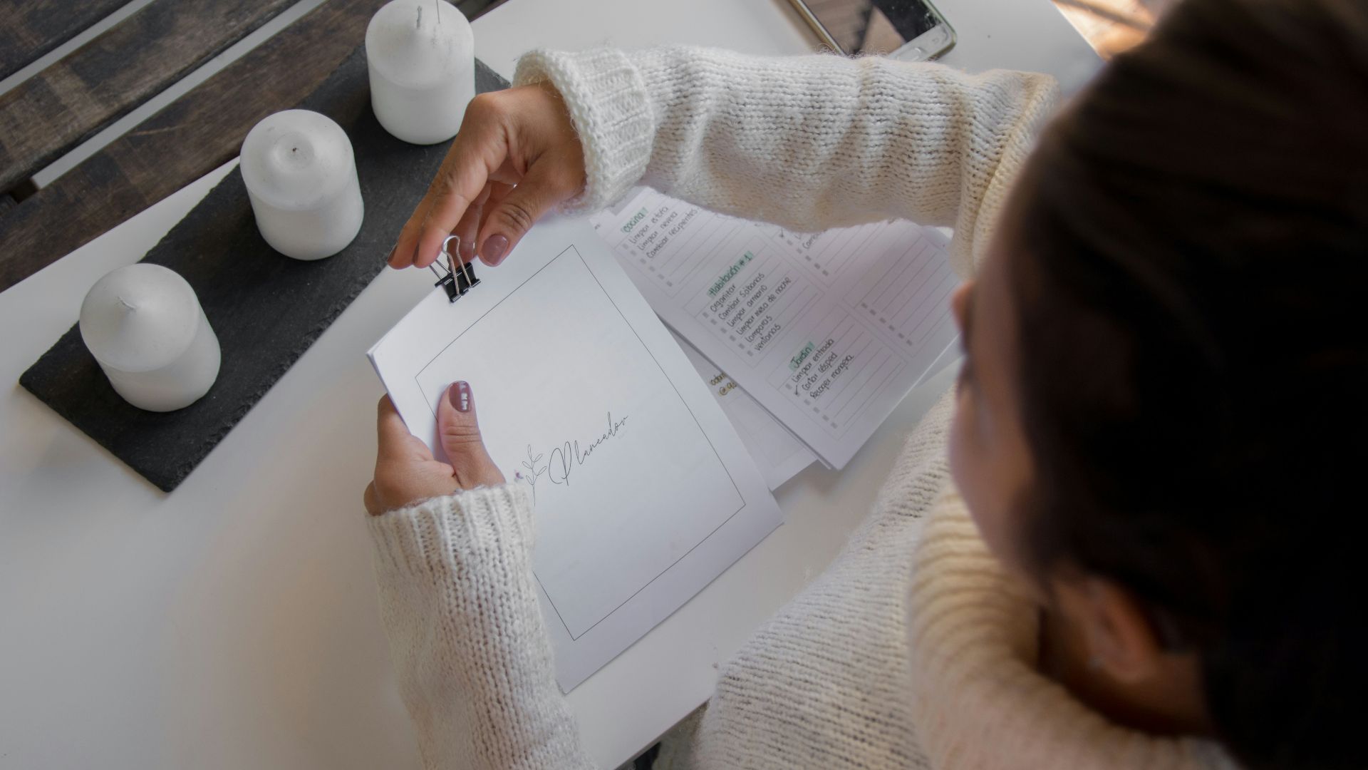person in white long sleeve shirt holding white printer paper