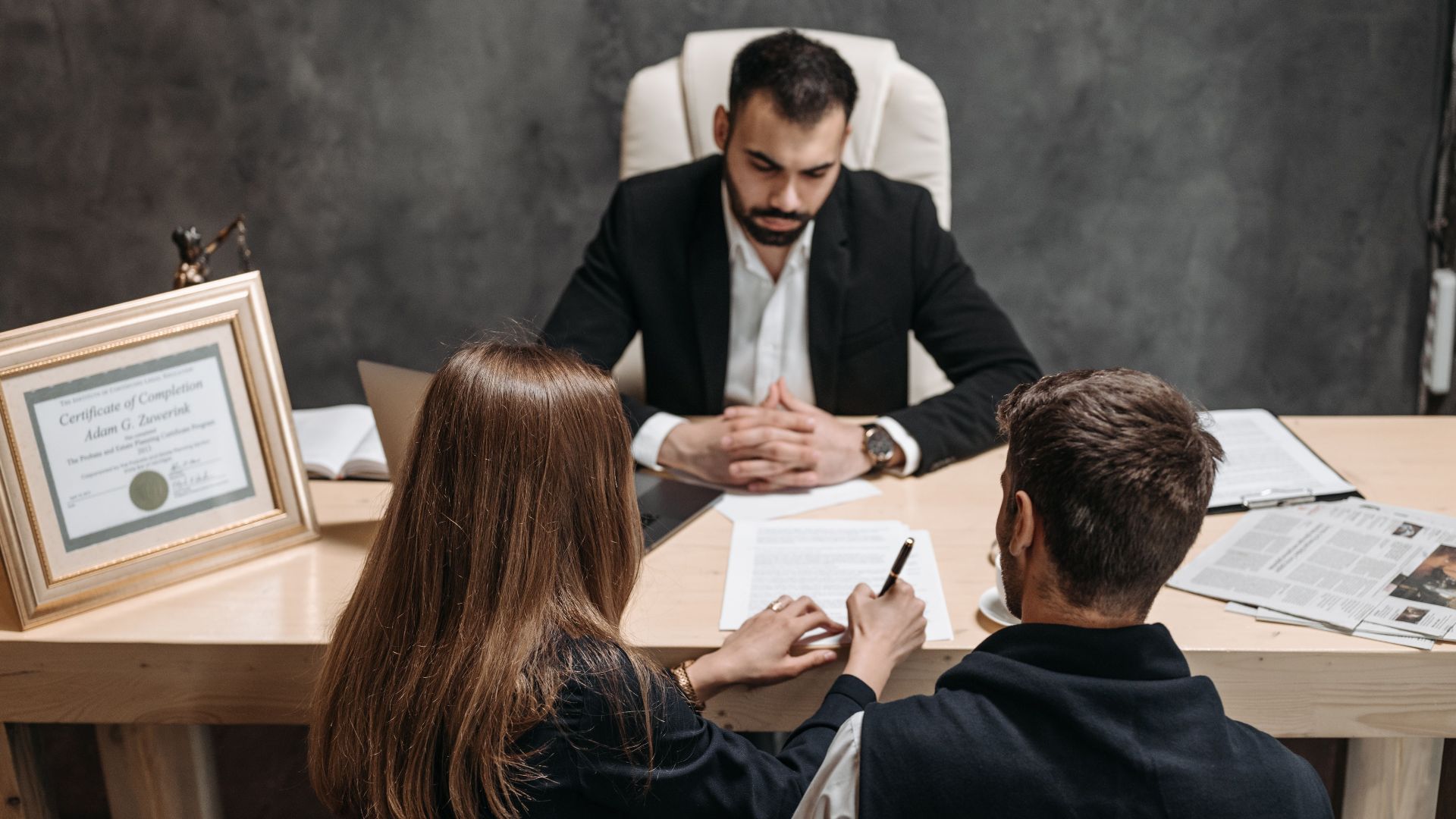 A lawyer discusses legal documents with clients in an office setting.