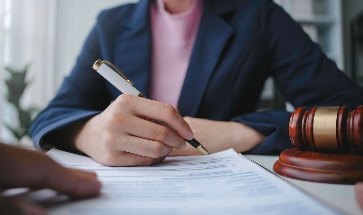 Lawyer is signing a last will and testament during a meeting with a client in their office