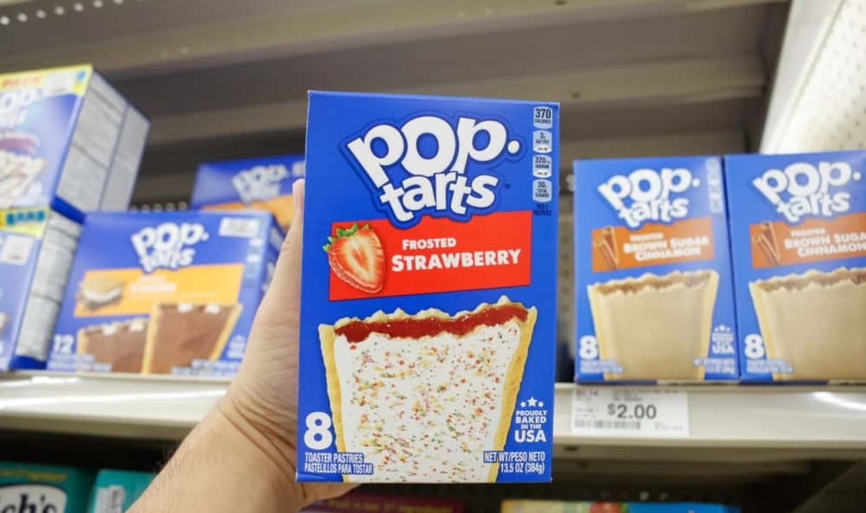  Los Angeles, California, United States - 02-12-2020: A view of a hand holding a box of Pop Tarts Frosted Strawberry, on display at a local grocery store.