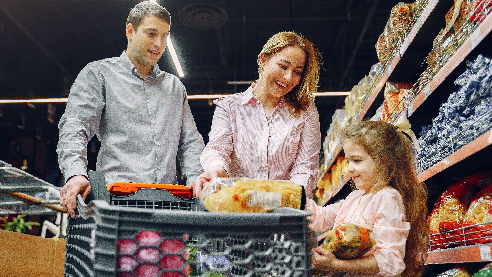 A joyful family of three shopping together in a supermarket, creating a memorable experience.