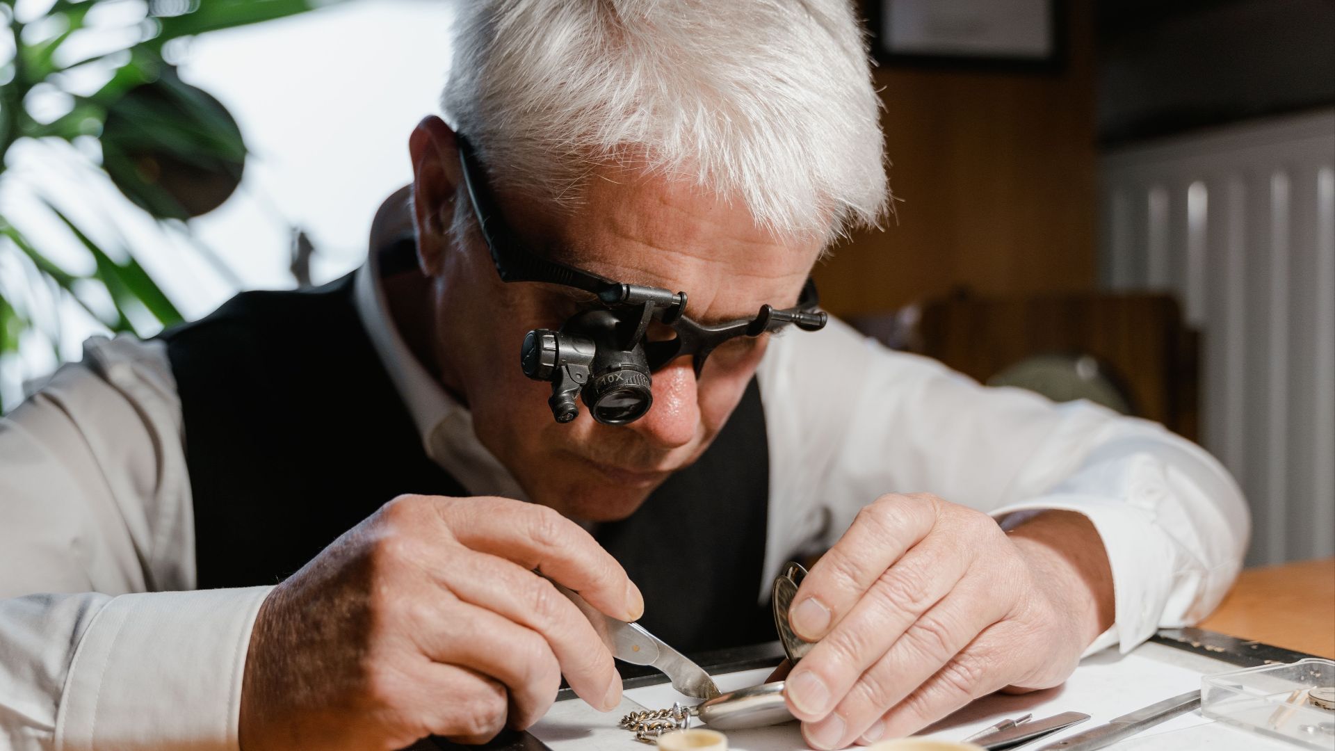 A watchmaker meticulously repairing a pocket watch with precision tools and a magnifier.