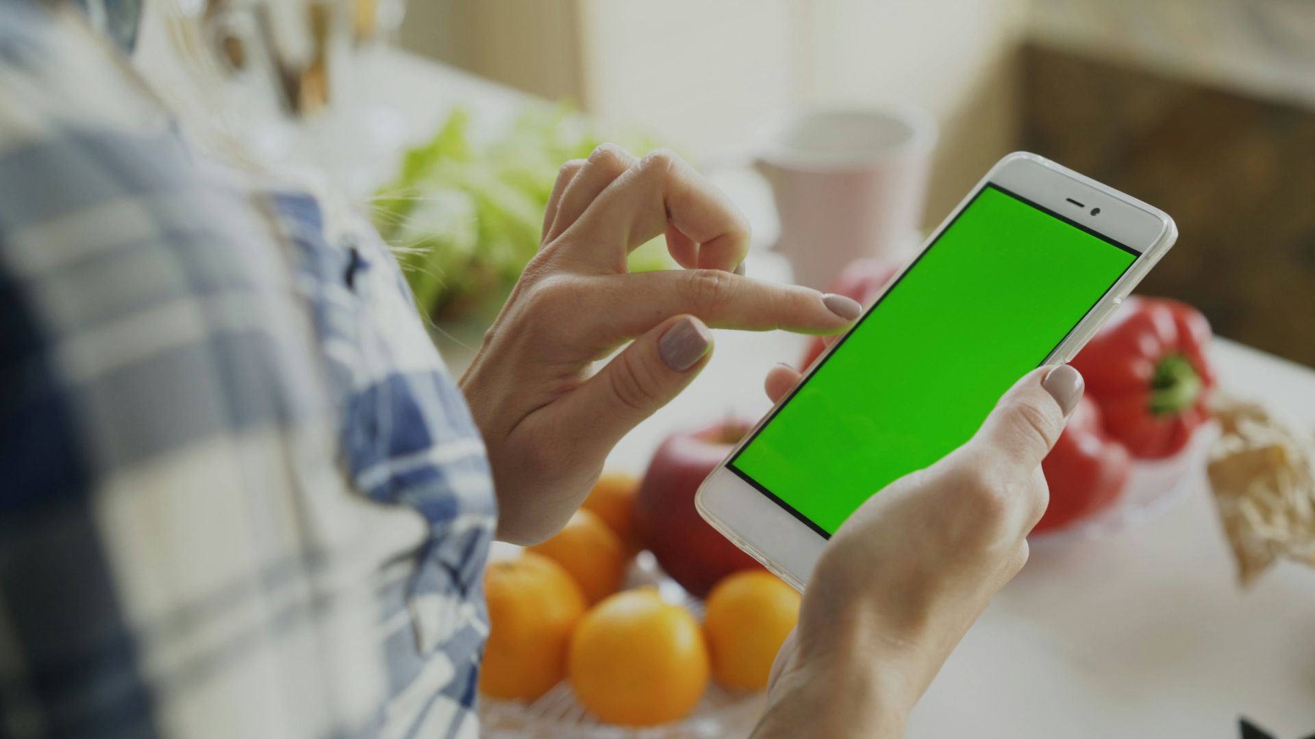 Person using a smartphone with a green screen