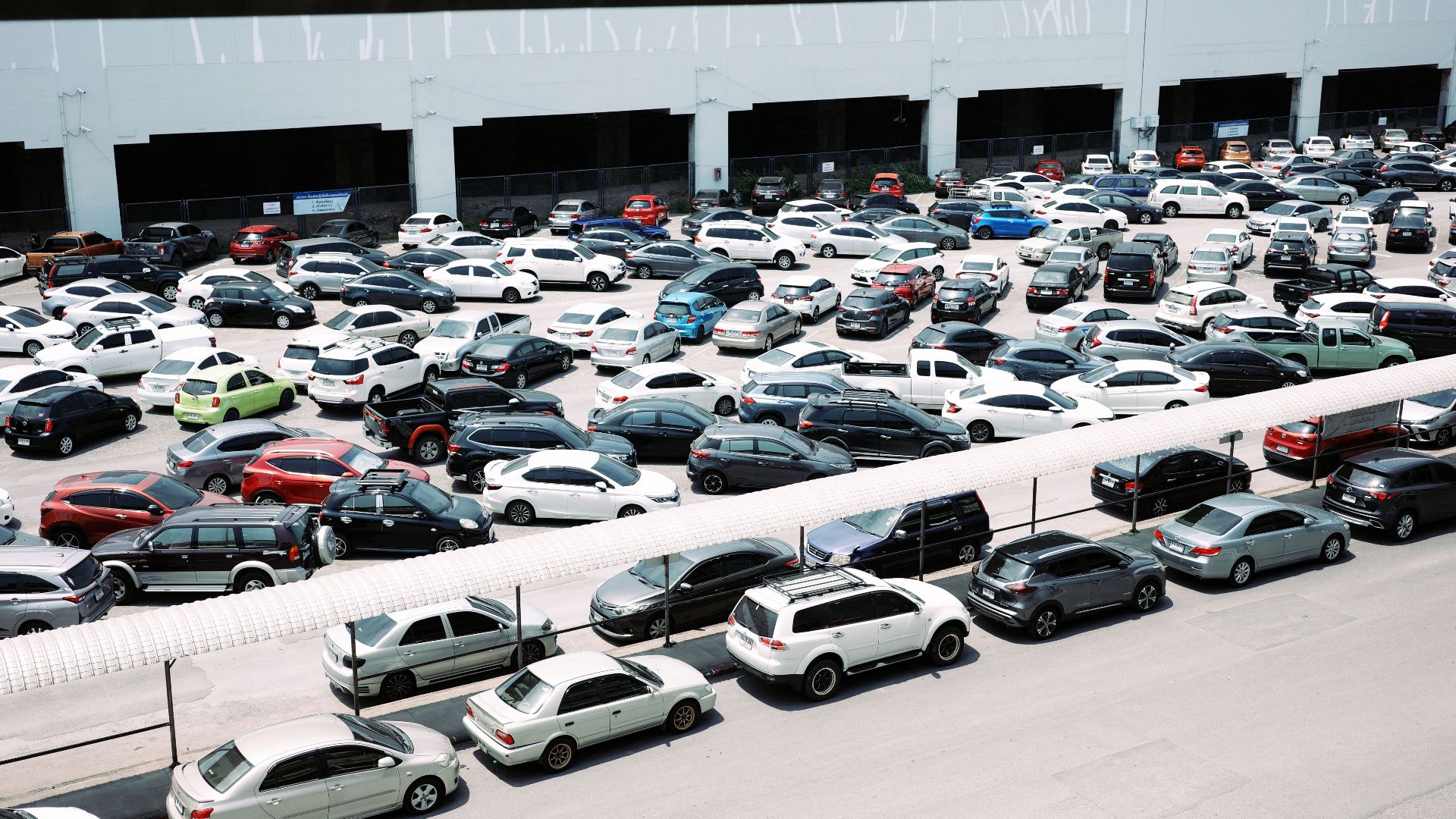 High-angle view of a crowded urban parking lot filled with various parked cars.