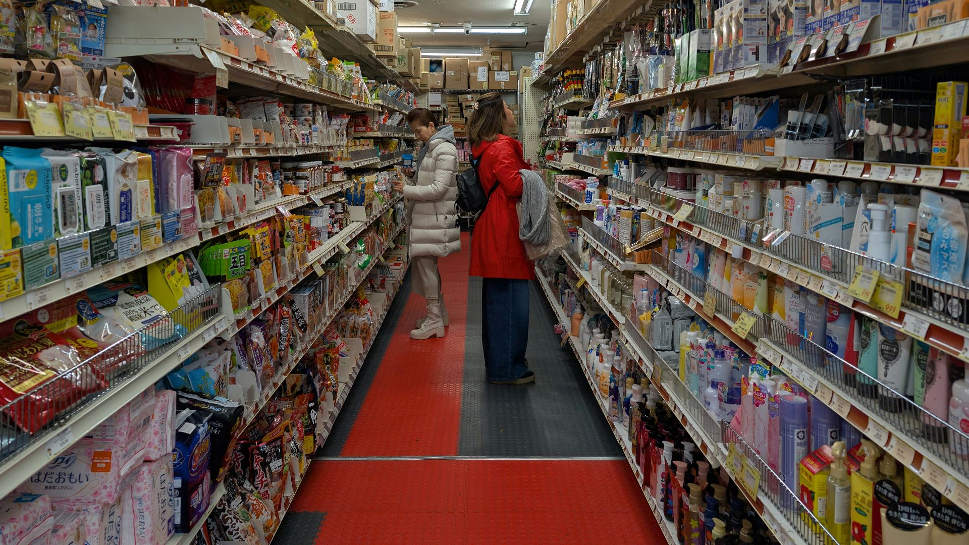 Aisle of a well-stocked retail store with many products.