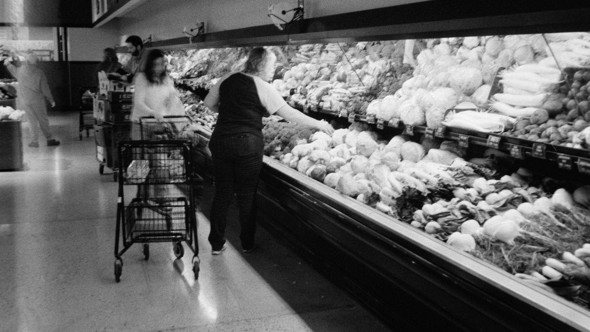 People shopping for produce in a grocery store.