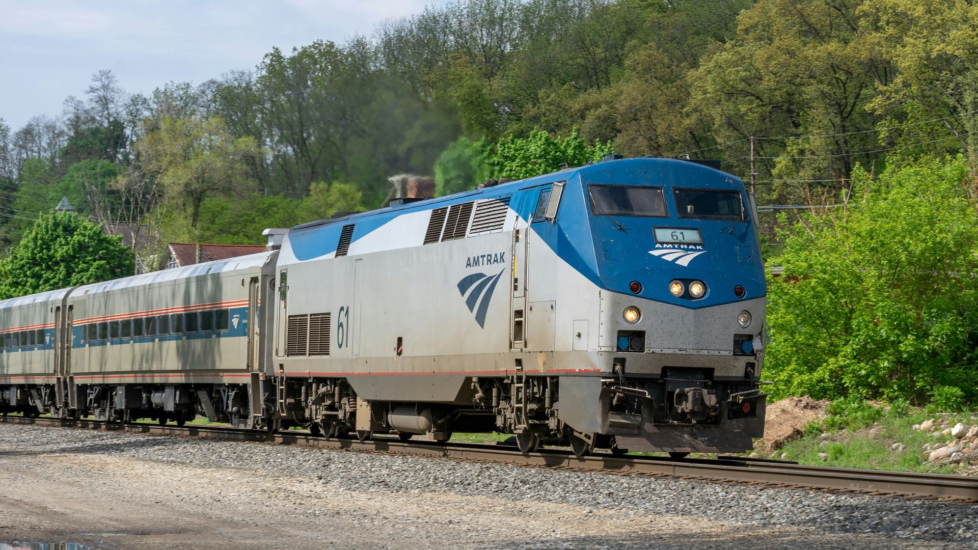 a blue and white train traveling down train tracks