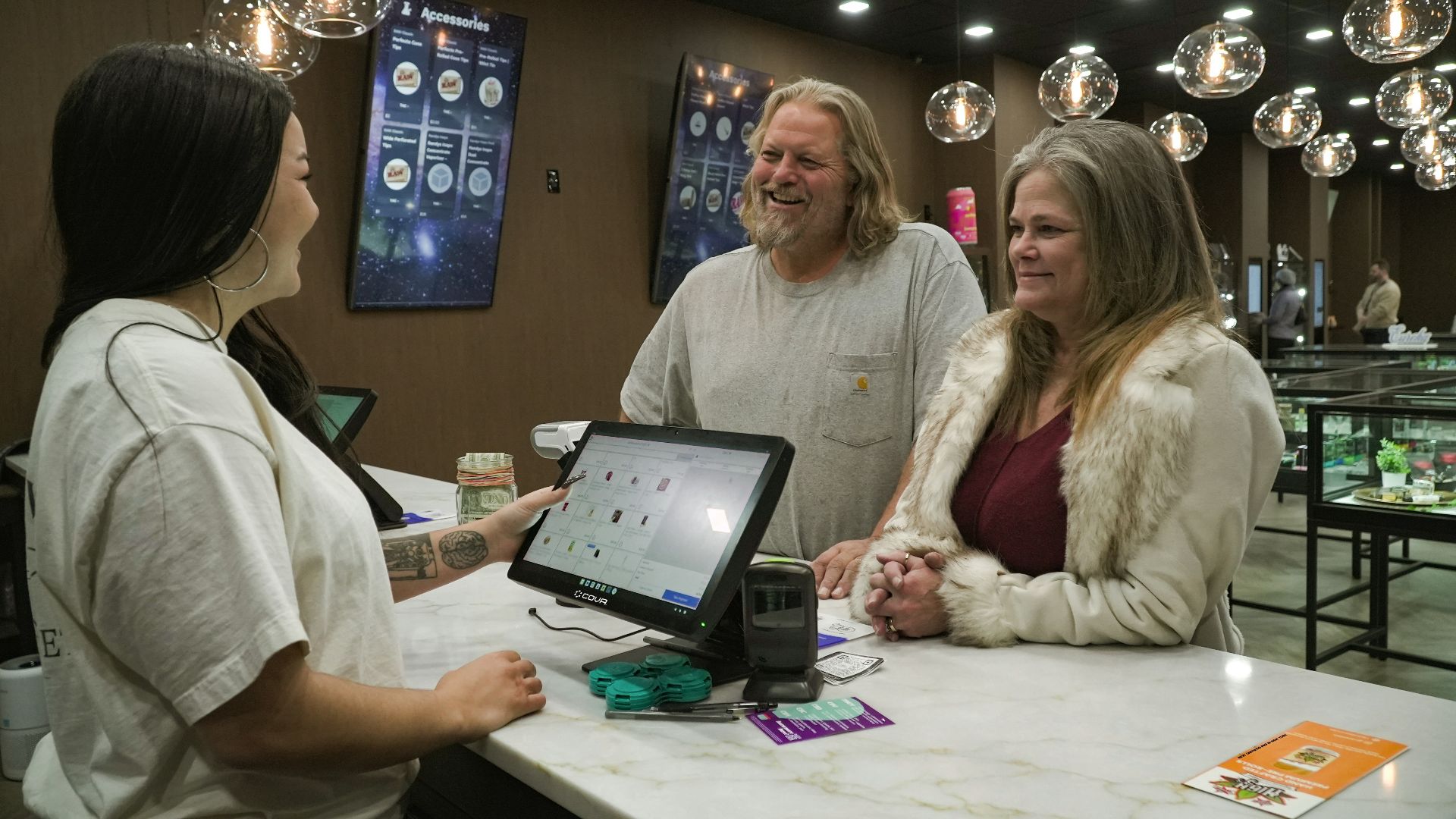 Customers interacting with a cashier at a counter