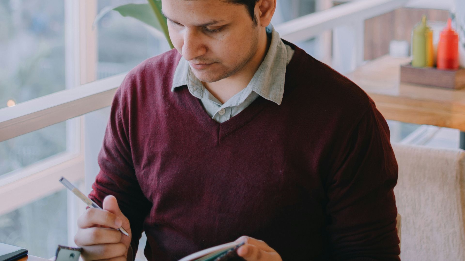 a man sitting at a table looking at a menu