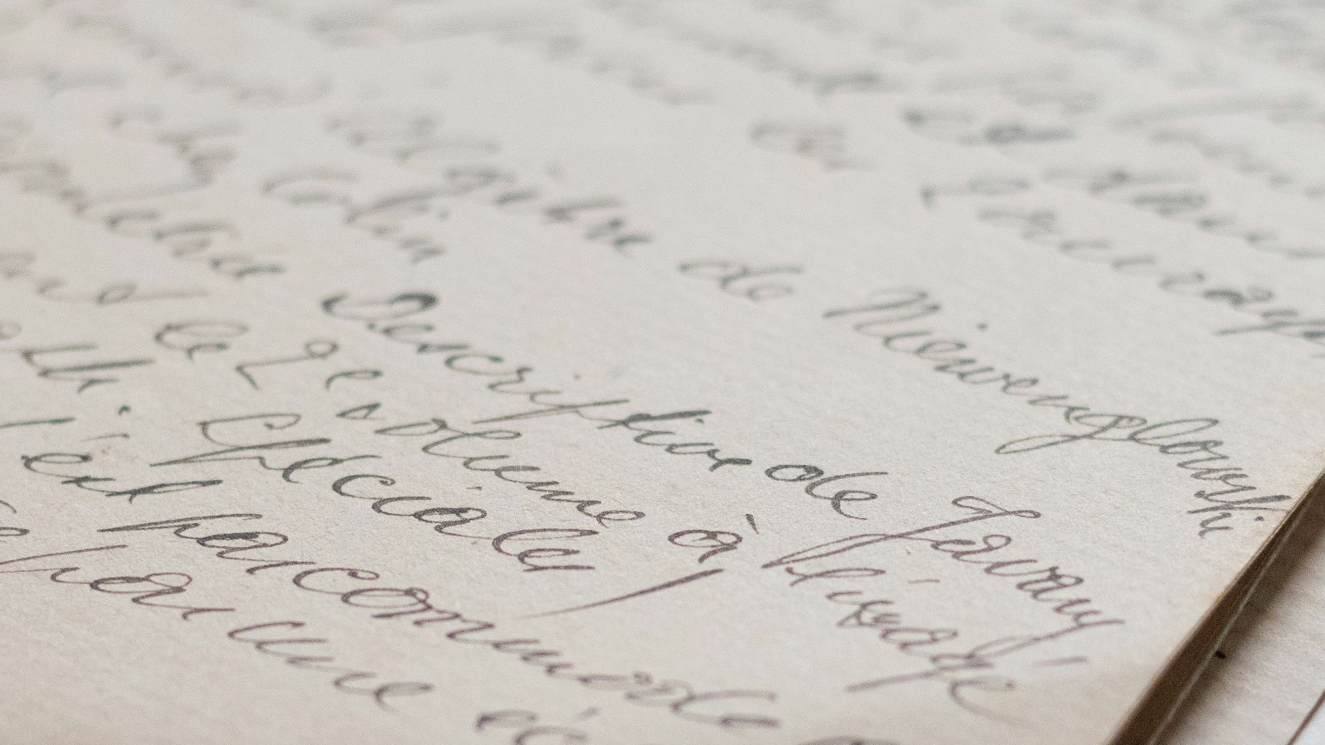 Old handwritten papers stacked on a light surface