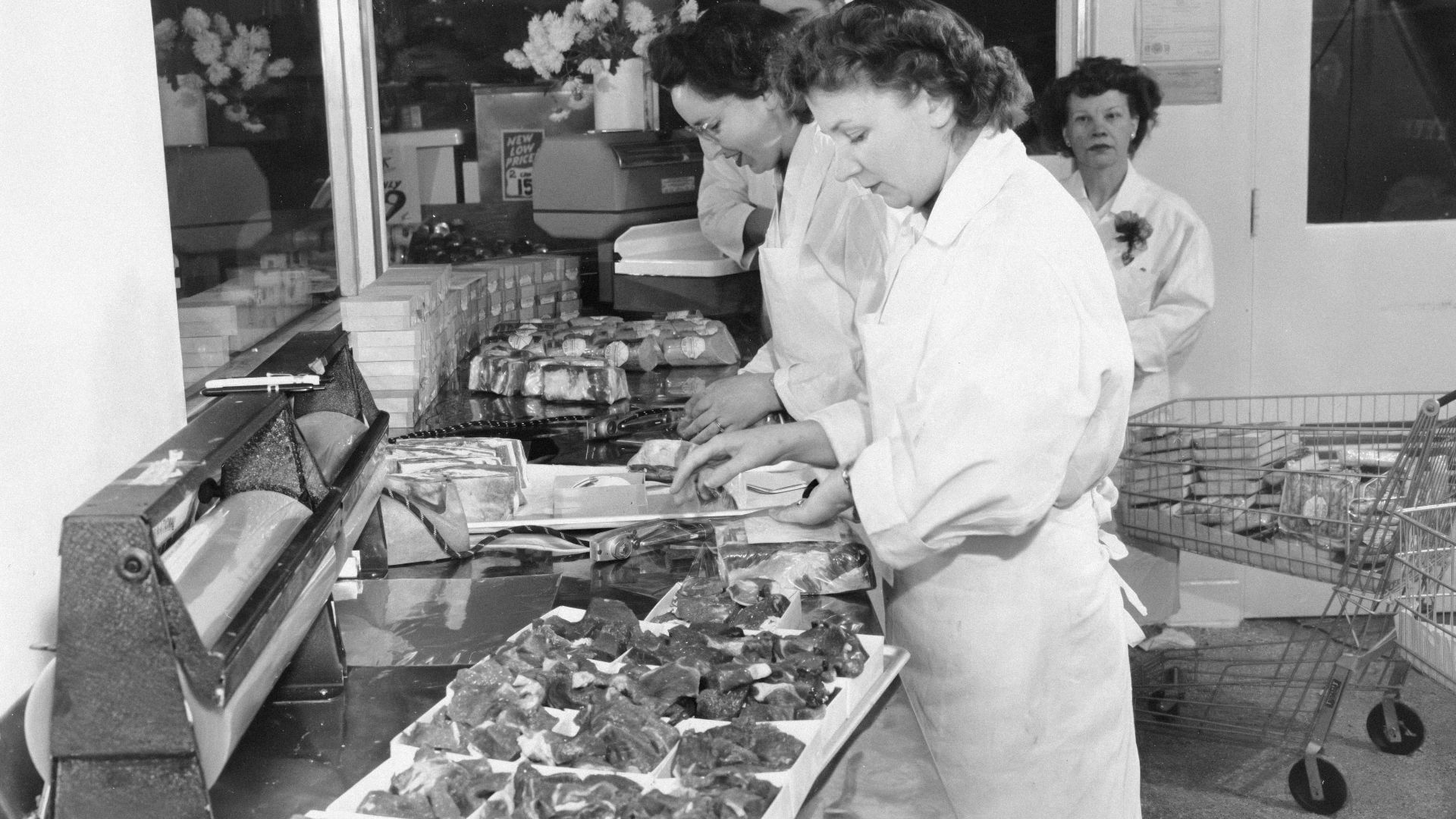 Workers arranging food in a market display