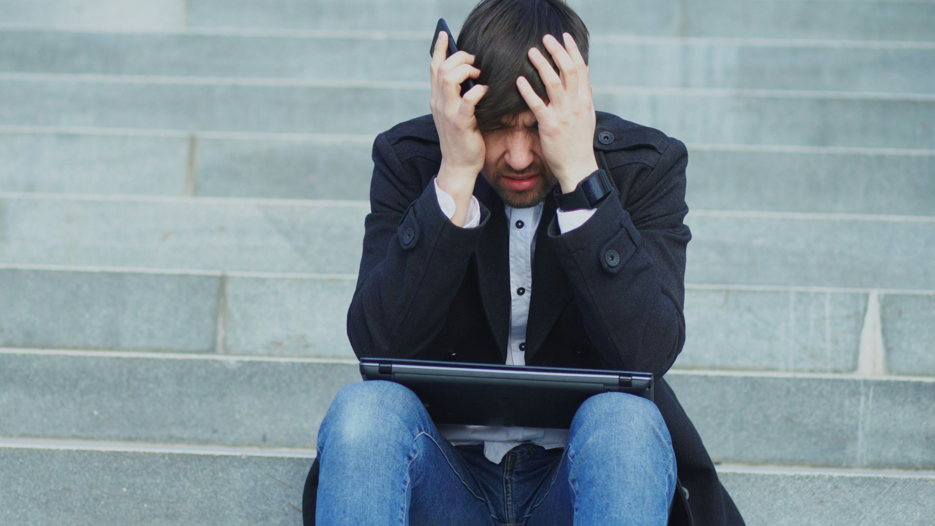 Man sitting on steps with head in hands