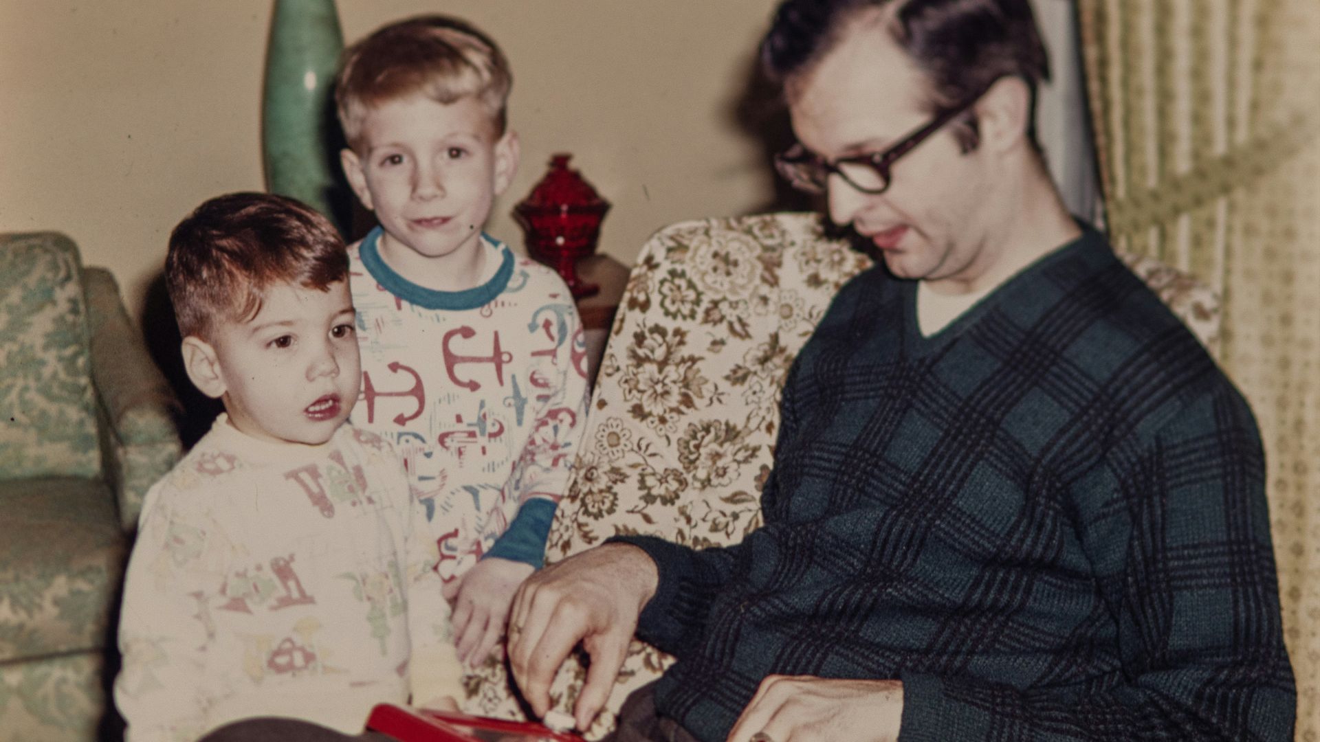 a man sitting on a couch with two boys