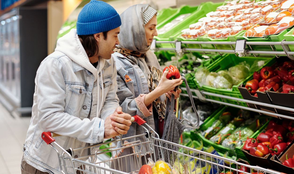 Middle Eastern couple selecting fresh vegetables at a supermarket