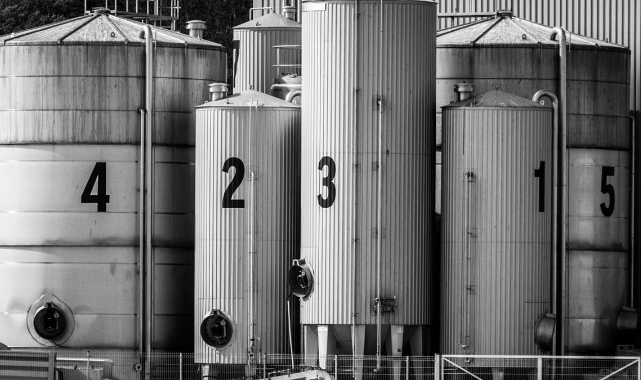 Black and white photo of industrial silos labeled with large numbers 1 to 5