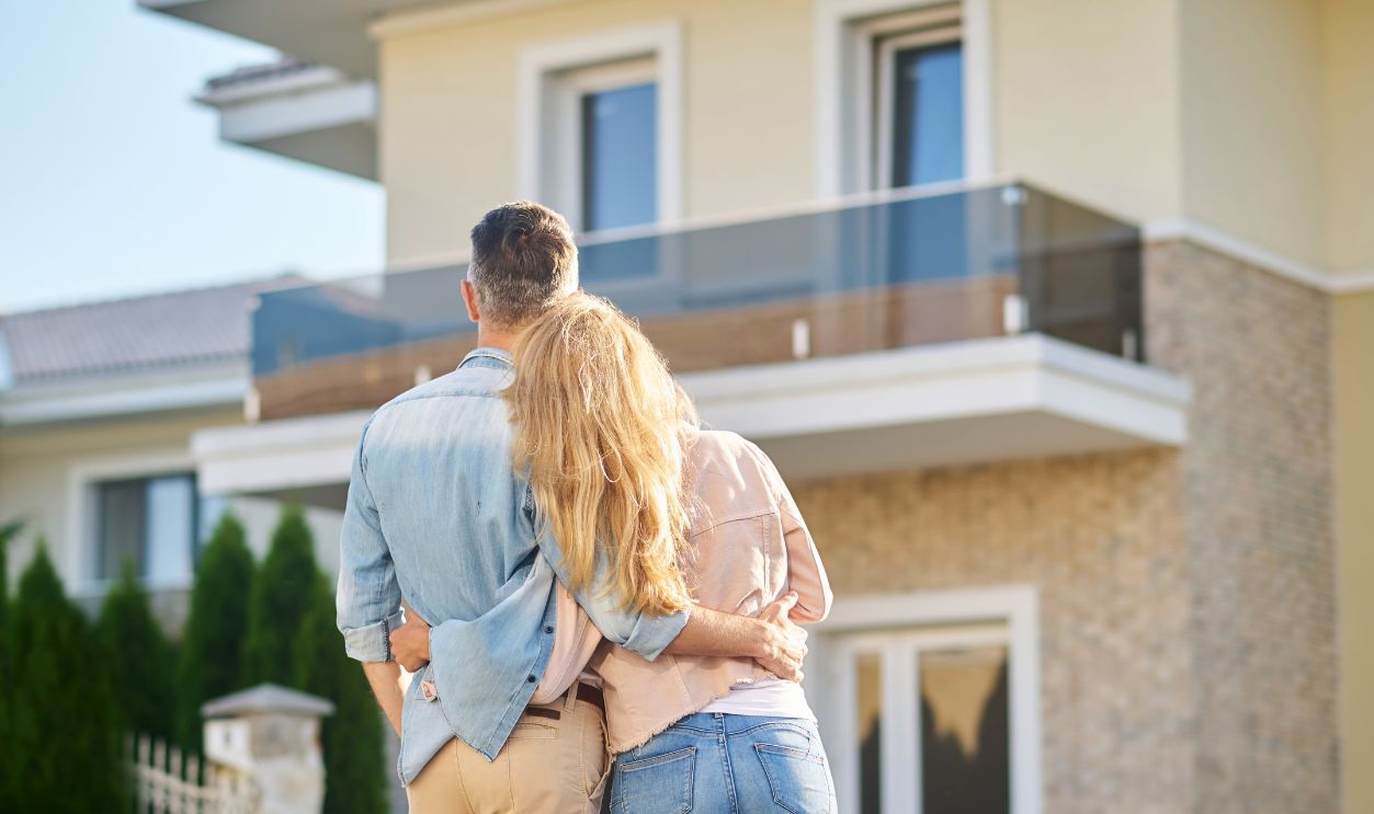 Back view of man and woman looking at house