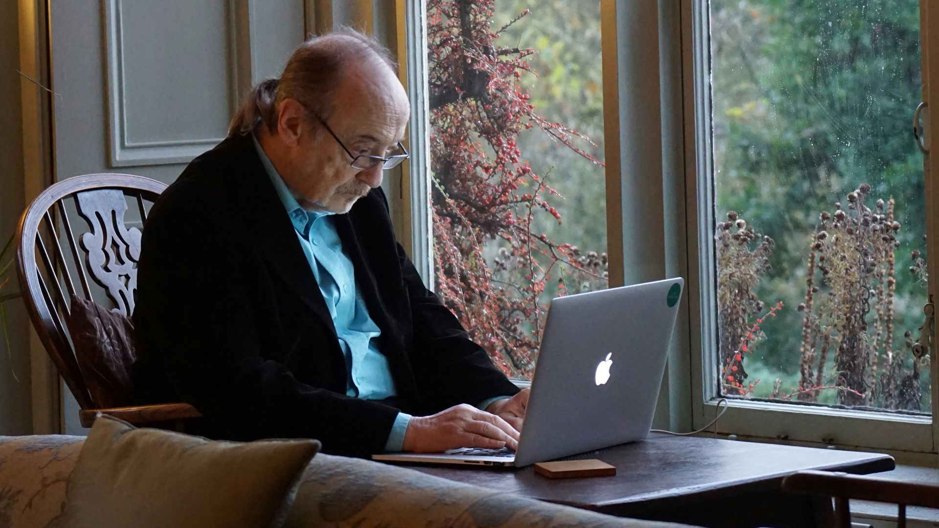 man in black suit jacket using macbook