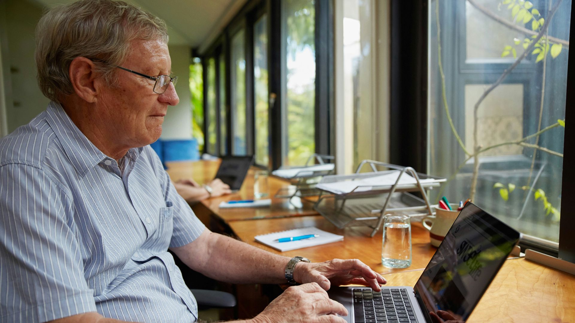 a man sitting at a table using a laptop computer