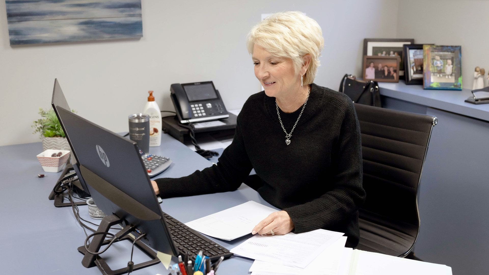 Woman works on laptop at her office desk.