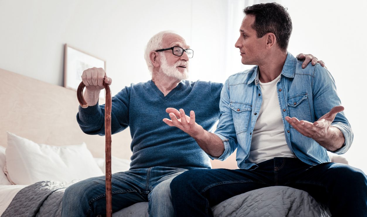 Shutterstock-1067089358, Pleasant communication. Pleasant nice elderly man looking at his grandson and holding his shoulder while talking to him