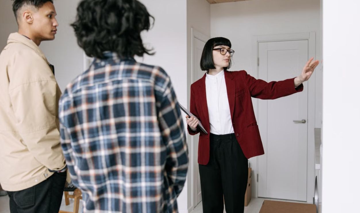 Real estate agent presenting an apartment to potential buyers during a property tour
