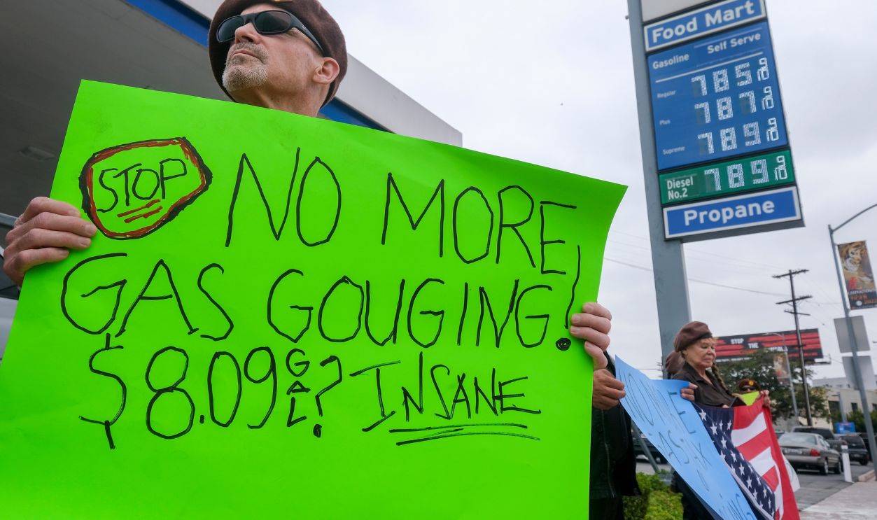 A member of the Brown Beret National Party holding a sign demonstrates against the high gasoline prices at a Chevron gas station June 4, 2022 in Los Angeles.