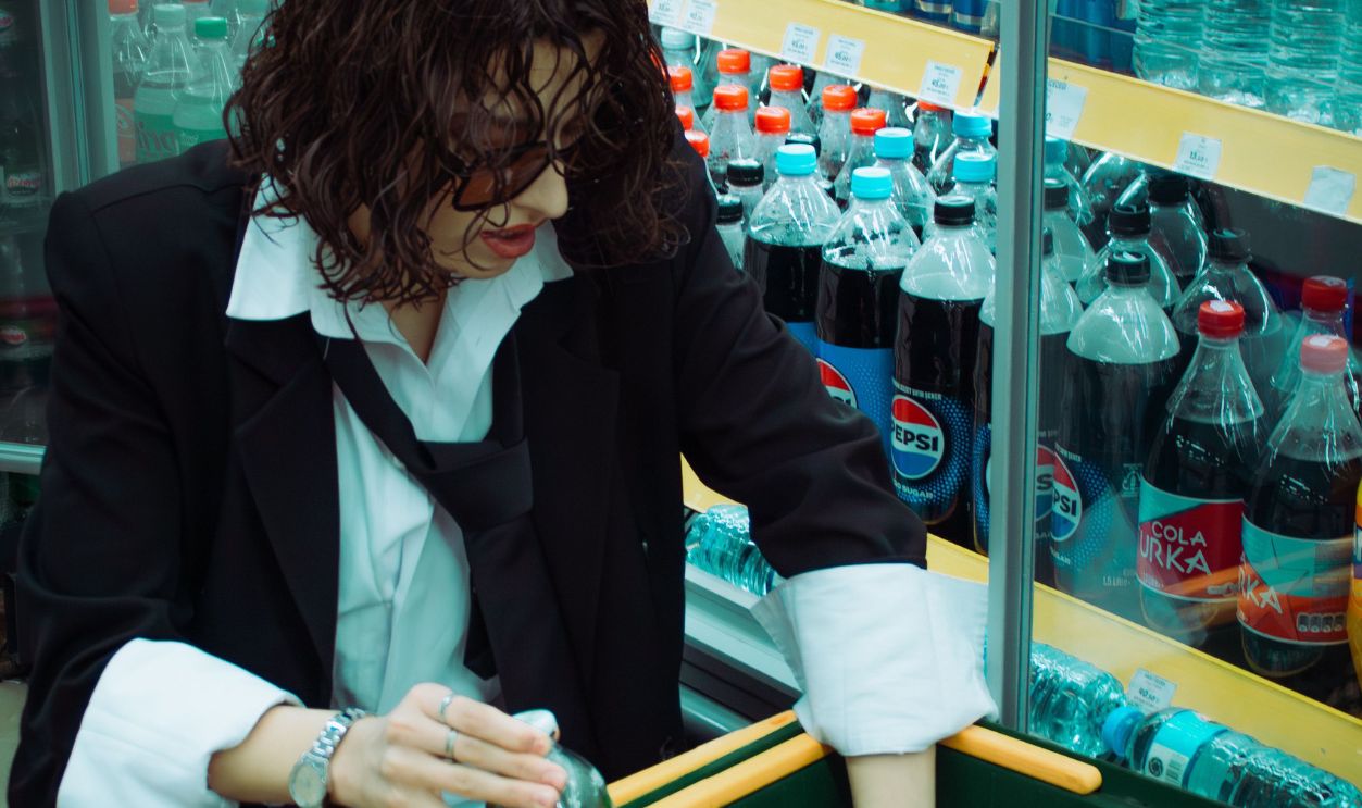 Female shopper in a supermarket drink aisle