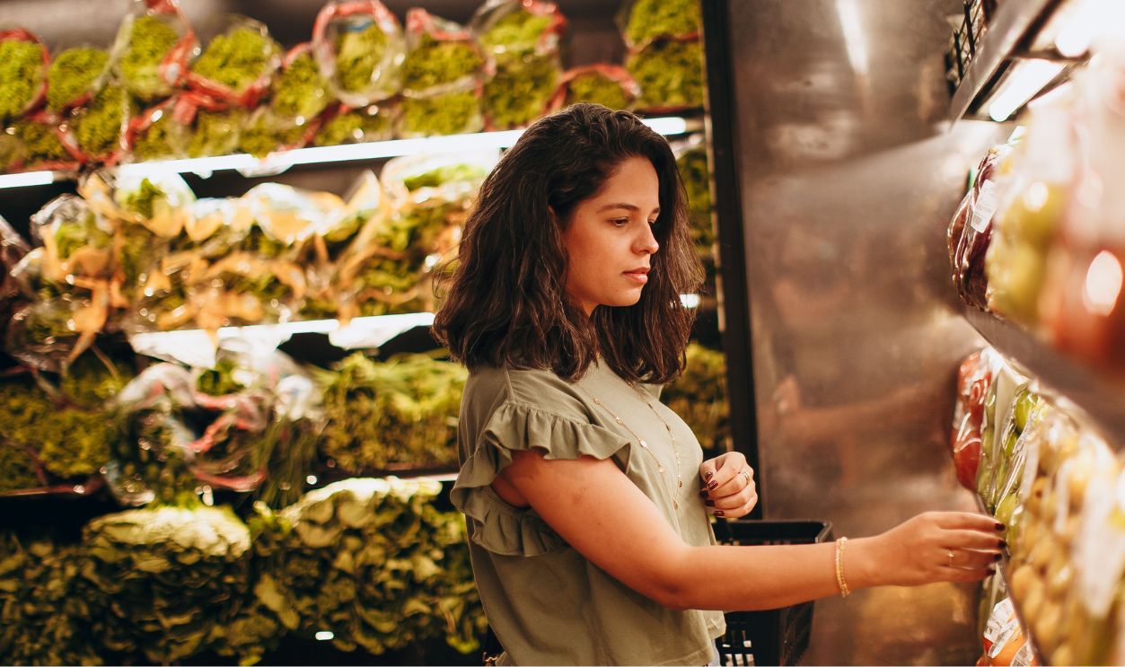 Young woman selecting fresh vegetables in a supermarket