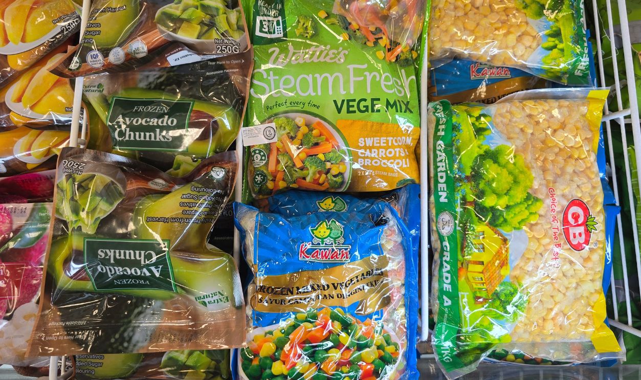 Penang, Malaysia - Feb 22, 2025: A selection of frozen vegetables including Wattie's Steam Fresh Vege Mix, Kawan mixed vegetables, GB Fresh Garden corn, and frozen avocado chunks at AEON Grocery.