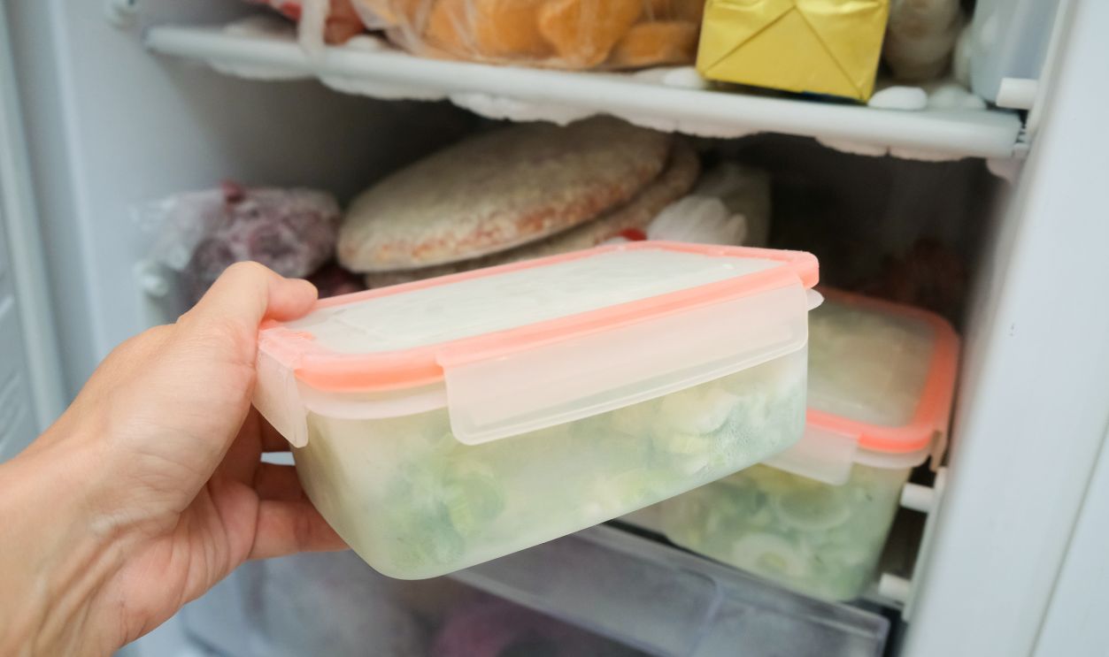 A glimpse of a packed freezer that showcases a variety of frozen items such as pizzas and vegetables