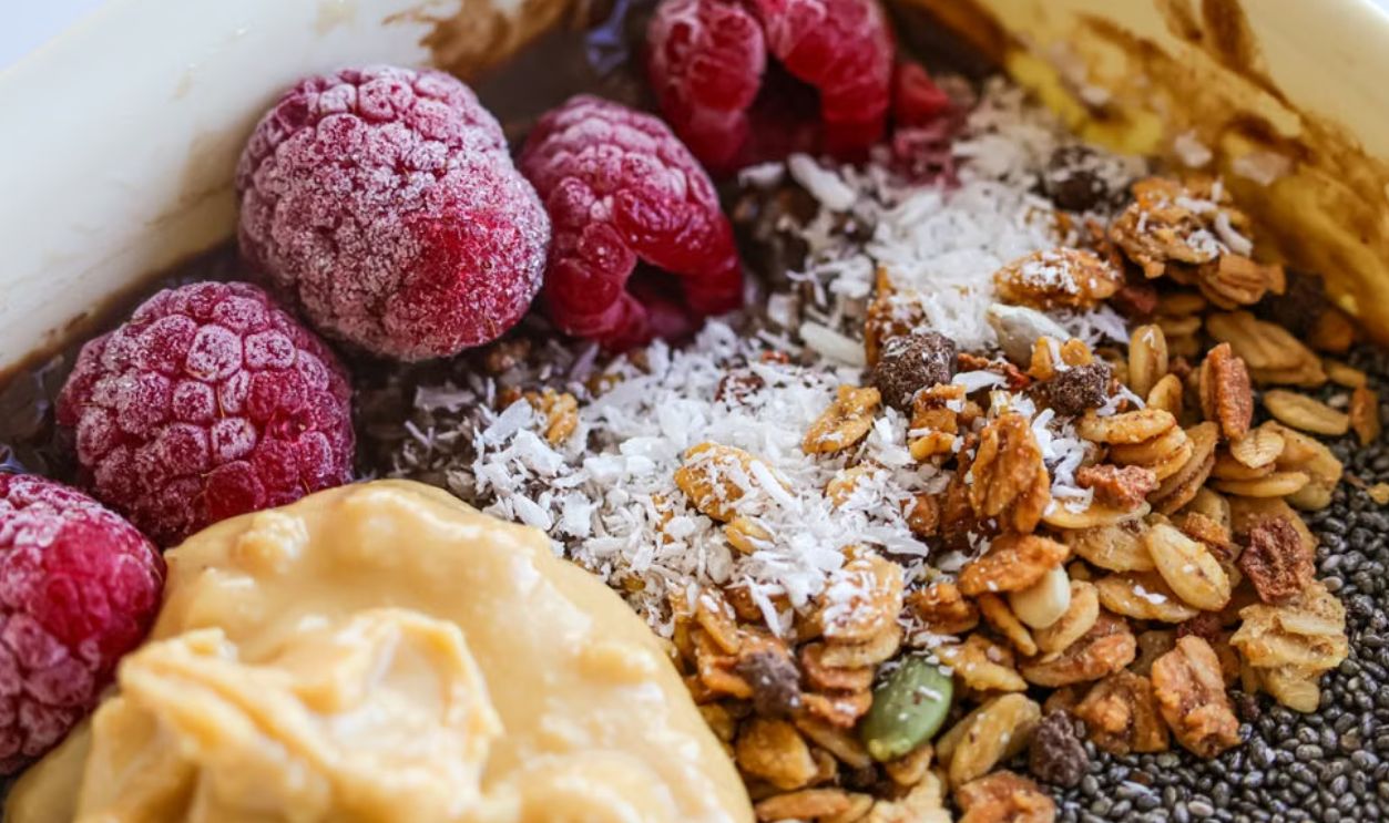 Delicious breakfast bowl with fresh raspberries, granola, and nut butter for a healthy start