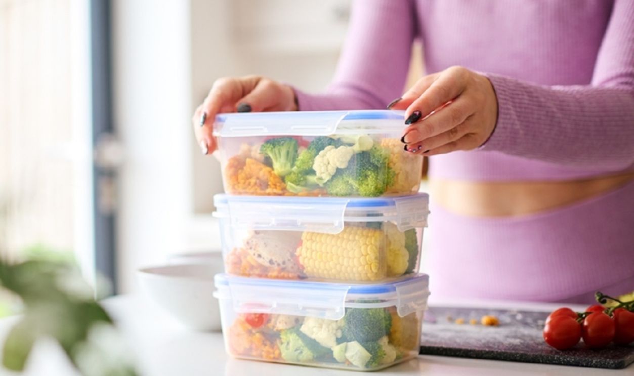 Woman At Home In Kitchen Making Healthy Meals For The Freezer