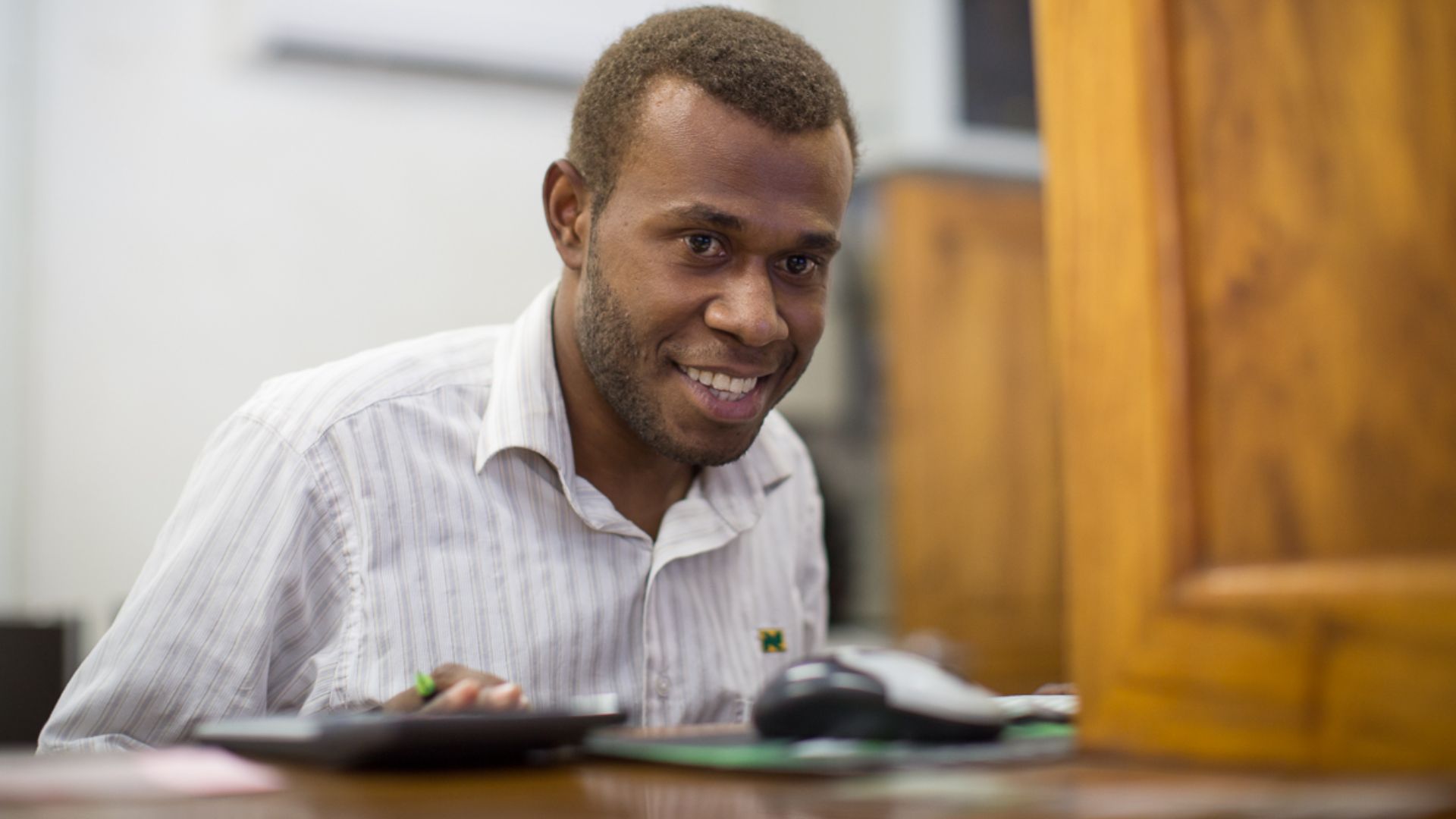 A bank teller serves a man at National Bank of Vanuatu on Malekula island. Photo taken by Connor Ashleigh for AusAID. (13/2529)