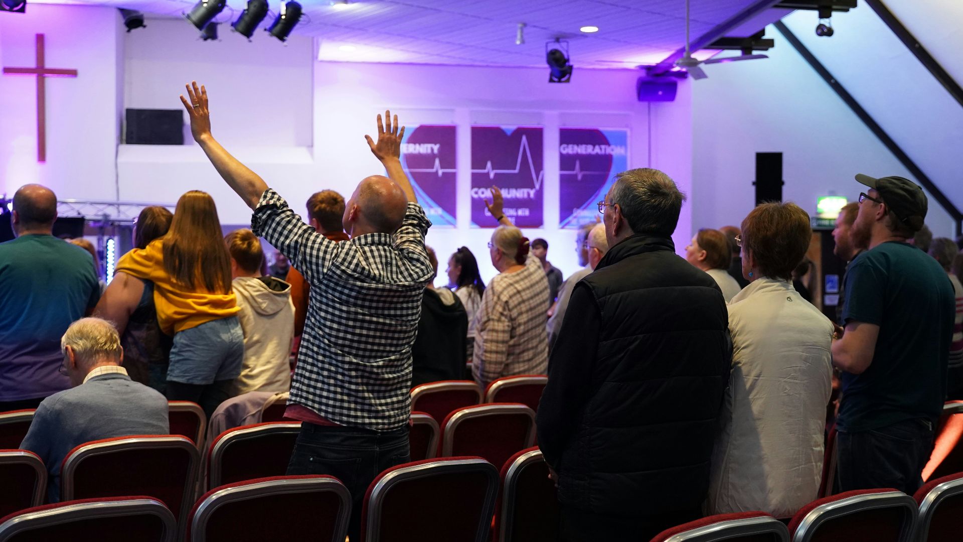 a group of people standing in a room with their hands in the air