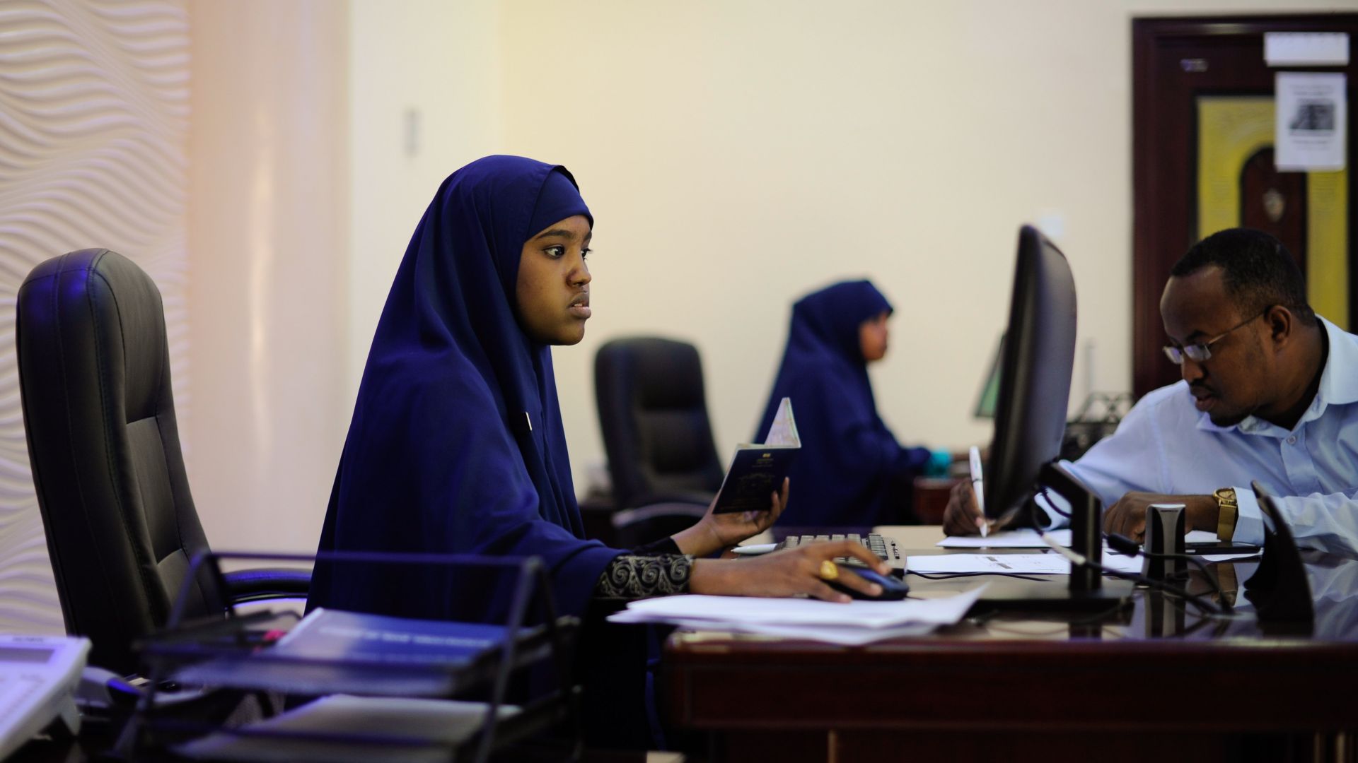 An employee of the International Bank of Somalia helps a new customer set up a bank account at their central headquarters in Mogadishu. AMISOM Photo