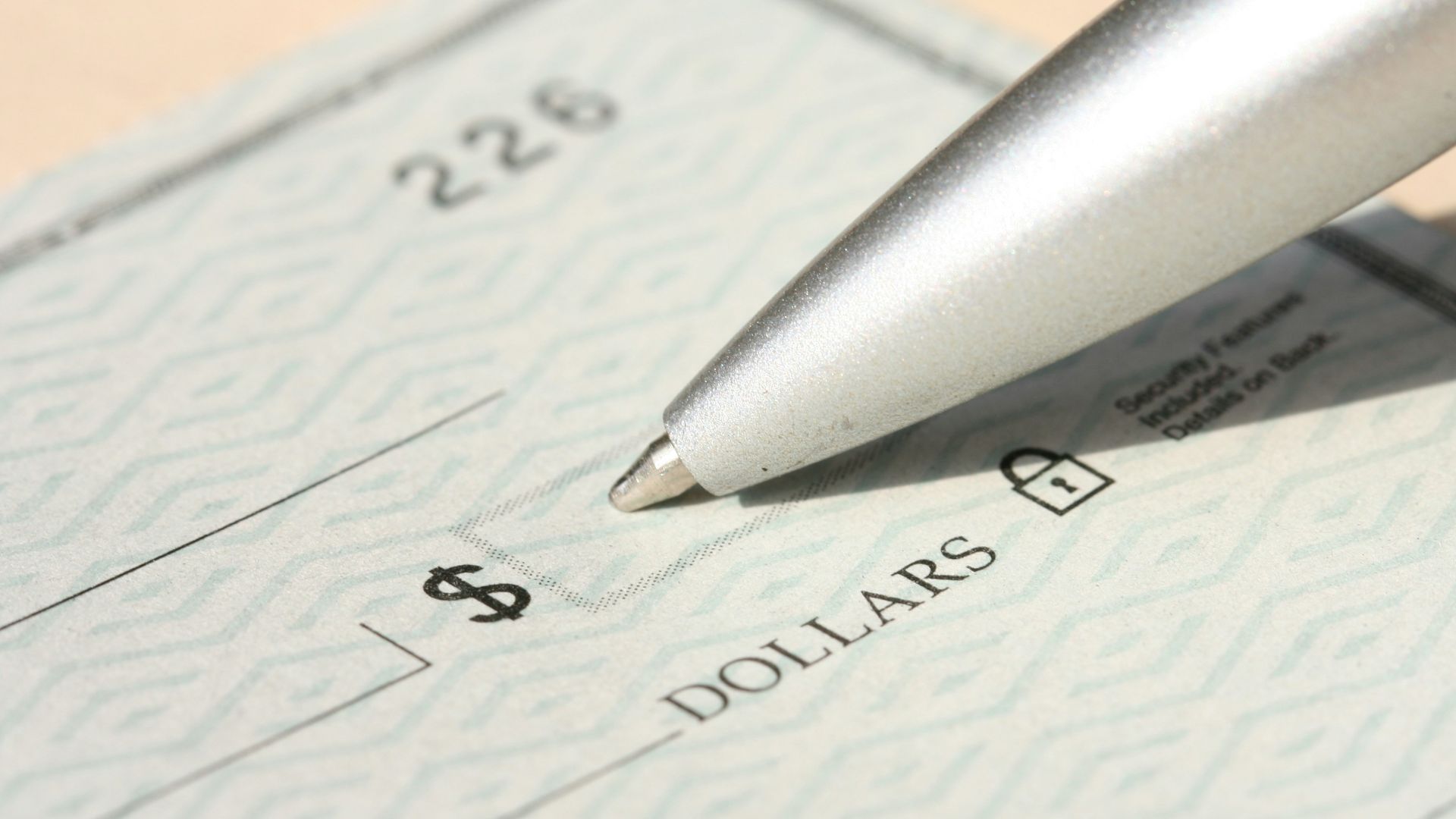 Pen poised over a check, ready to write.