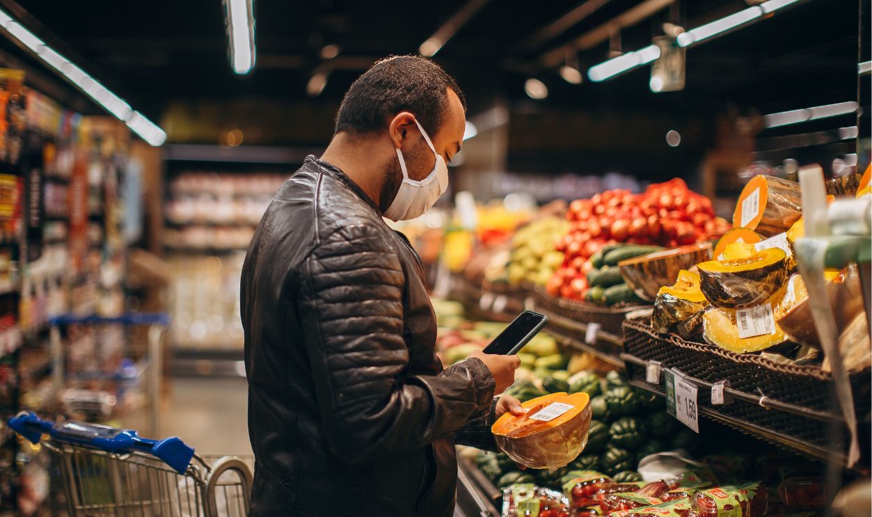 Man shopping in grocery store, inspecting fresh produce