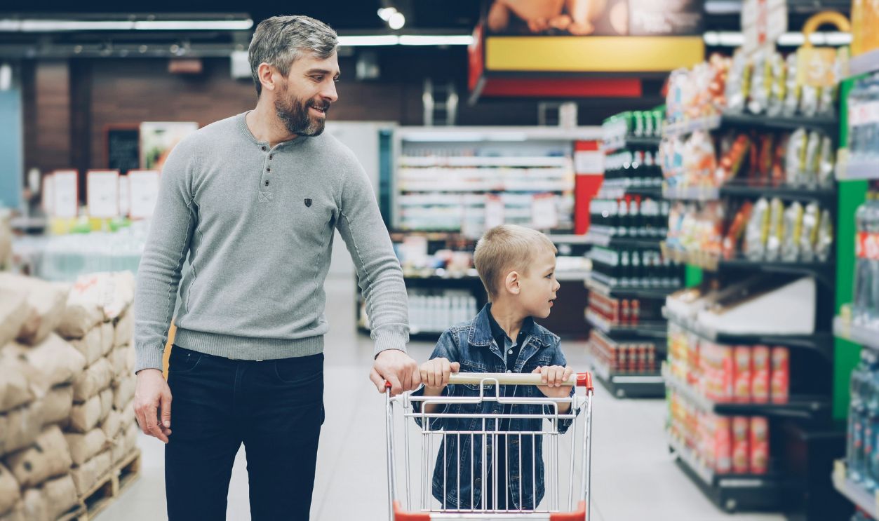 A father and son shop together in a supermarket