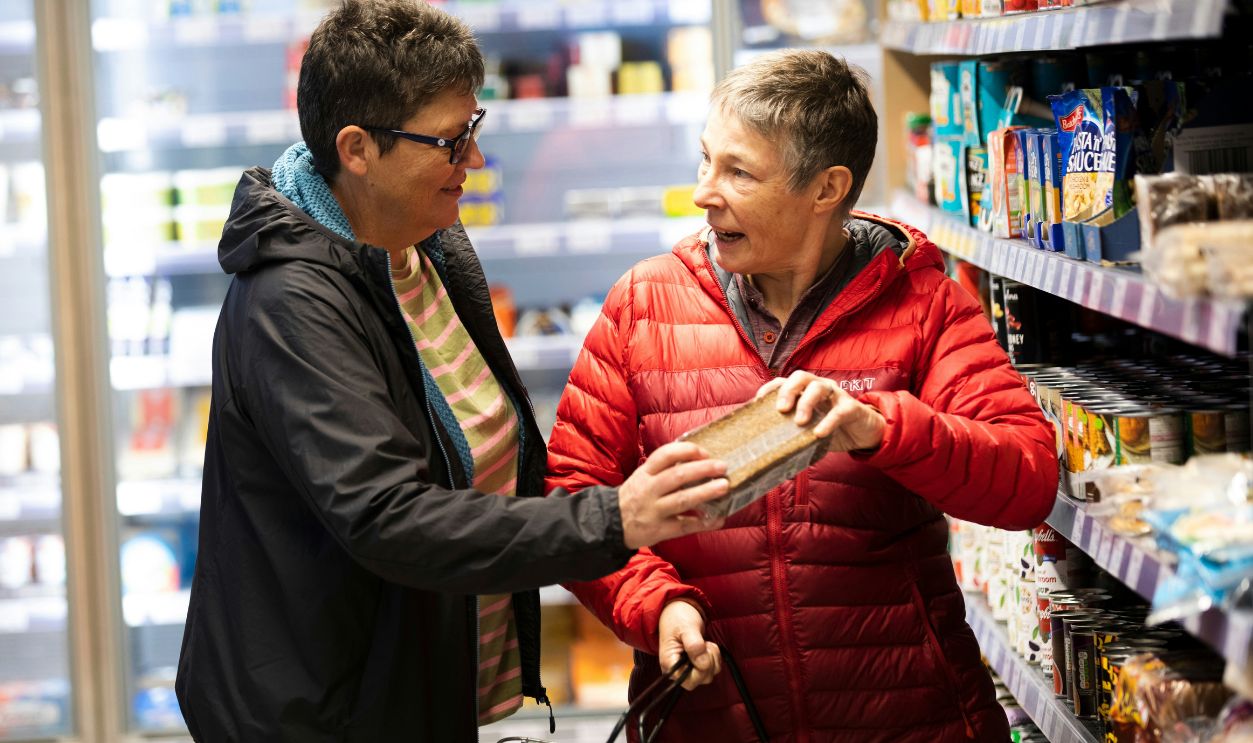 A man and a woman shopping in a grocery store